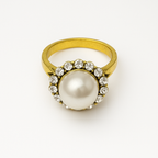 Vintage Pearl Halo Ring featuring a central pearl surrounded by sparkling crystals and a gold-toned band.