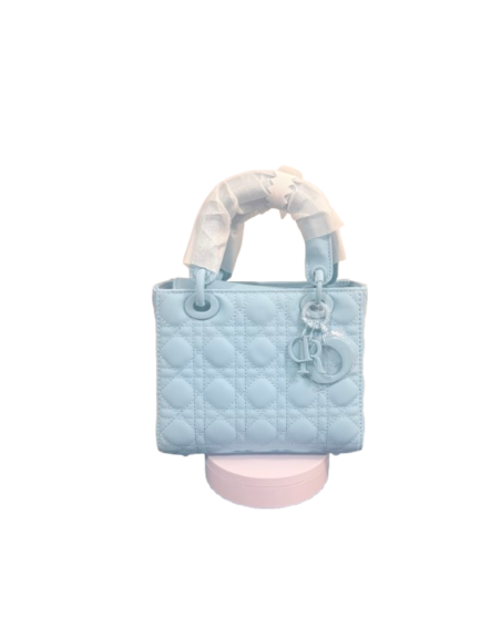 Stylish Lumivelle handbag in Ion Blue with GeoQuilt texture showcased on a pink display. Perfect accessory for any outfit.